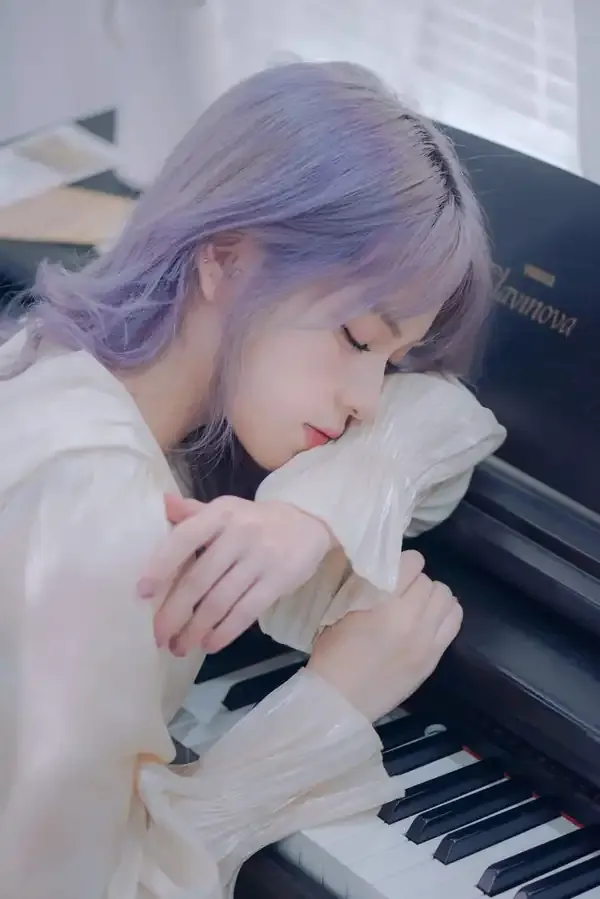 Uma pianista de cabelos lilás repousa junto ao piano.